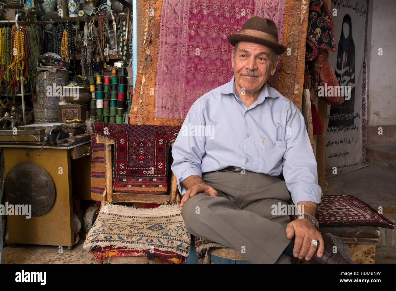 Ein Lieferant sitzt an der Vorderseite des seinem Kunsthandwerk Stall in Isfahan Basar, Provinz Isfahan, Iran Stockfoto