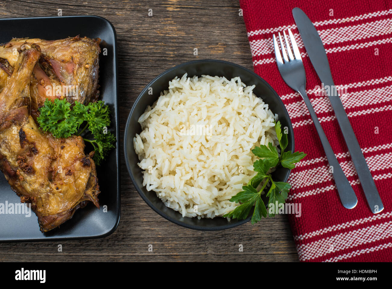 Gegrillte Hähnchenschenkel mit Reis auf den Tisch mit Besteck Stockfoto