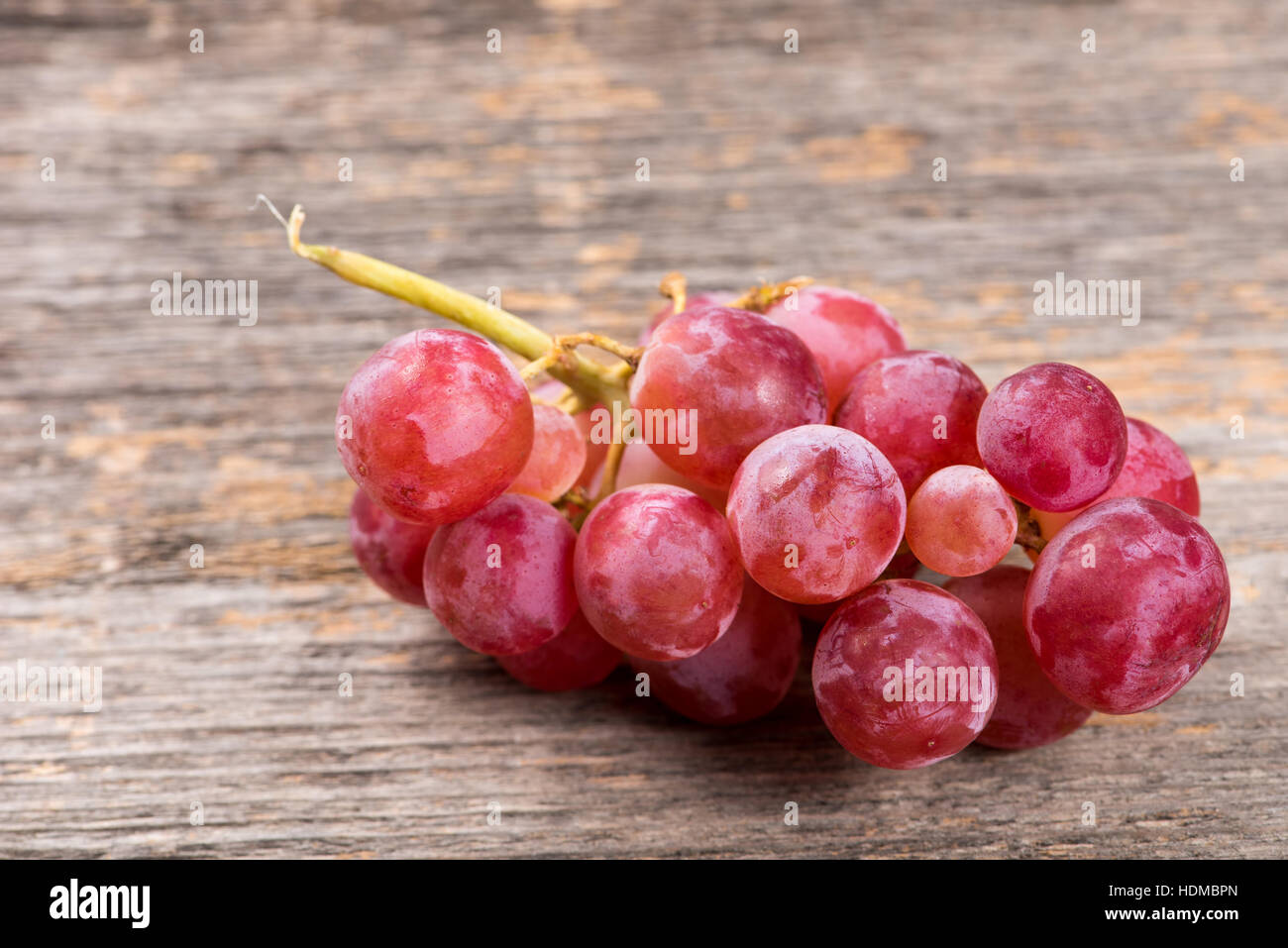 Rosa Bündel Weintrauben auf dem Holztisch in natürlichem Licht Stockfoto