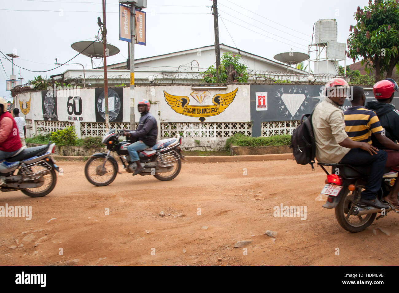 Okada (Taxi) vor dem Diamons-Händlerbüro in Kenema, Sierra Leone. Solche Satellitenschüsseln deuten auf internationale Handelsbeziehungen hin Stockfoto