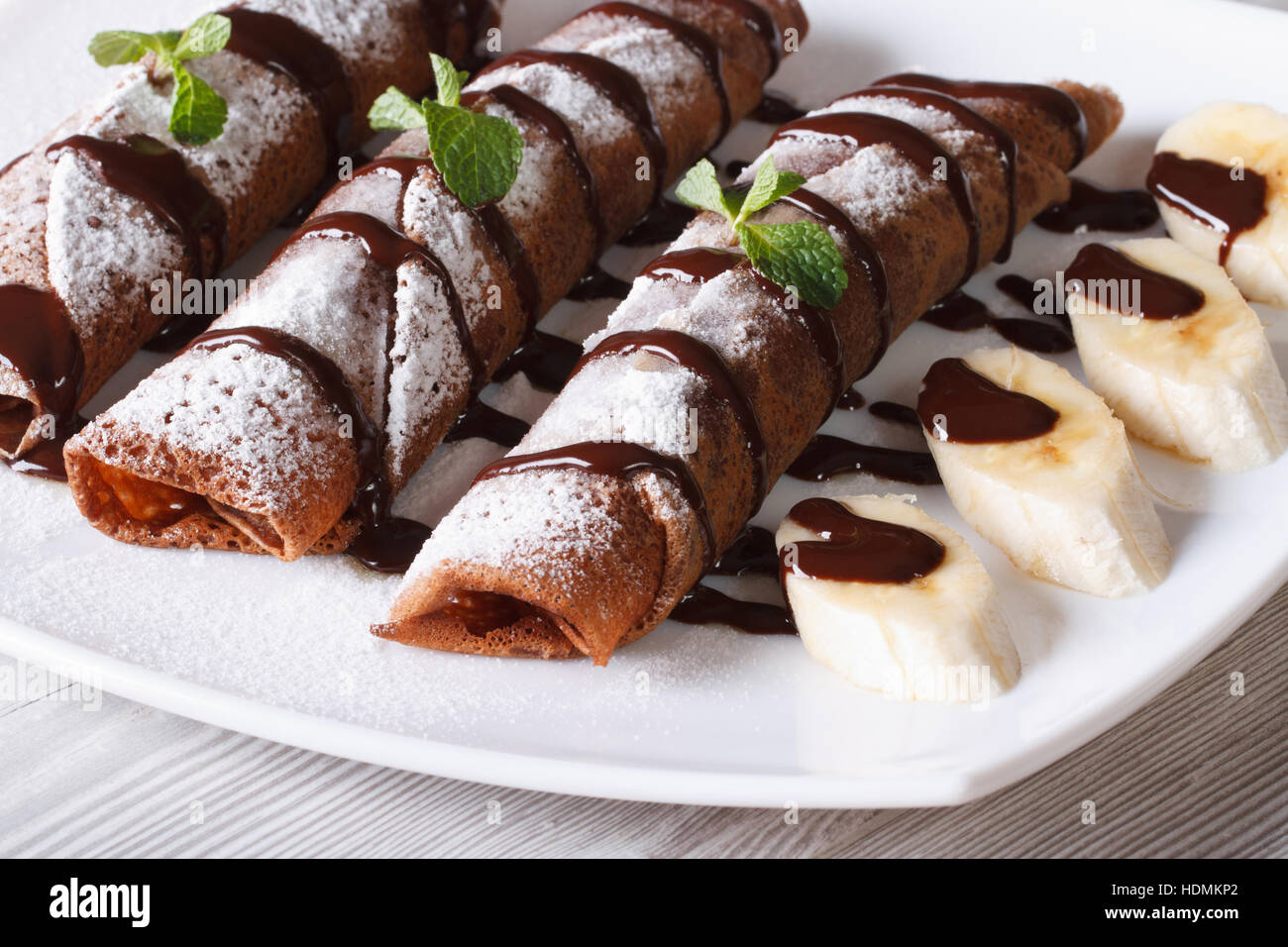 Schokolade Crepes mit Früchten und Sauce auf einer Platte Nahaufnahme. horizontale Stockfoto
