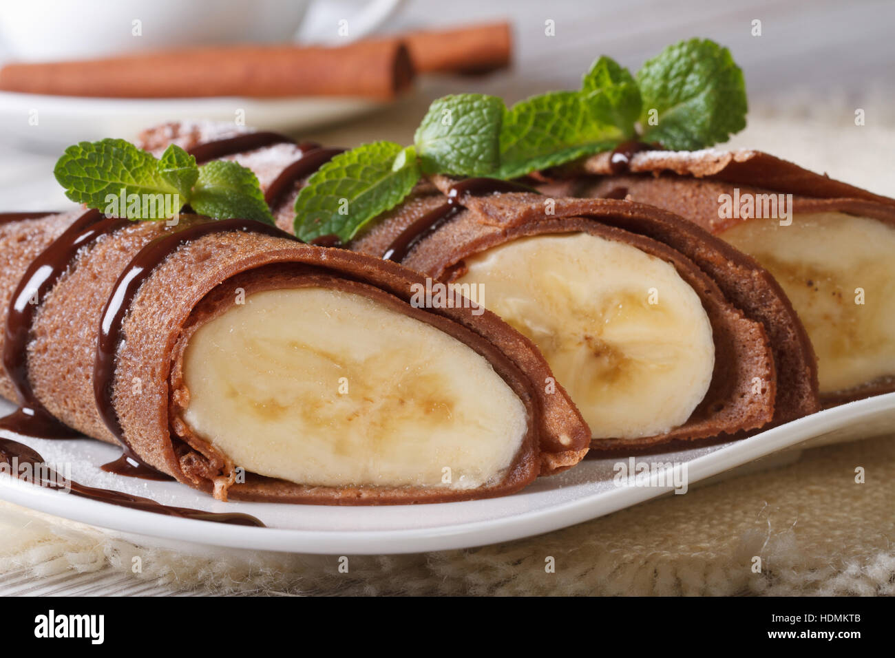 Schokolade Pfannkuchen mit Bananen Füllung Nahaufnahme auf einem weißen Teller. horizontale Stockfoto