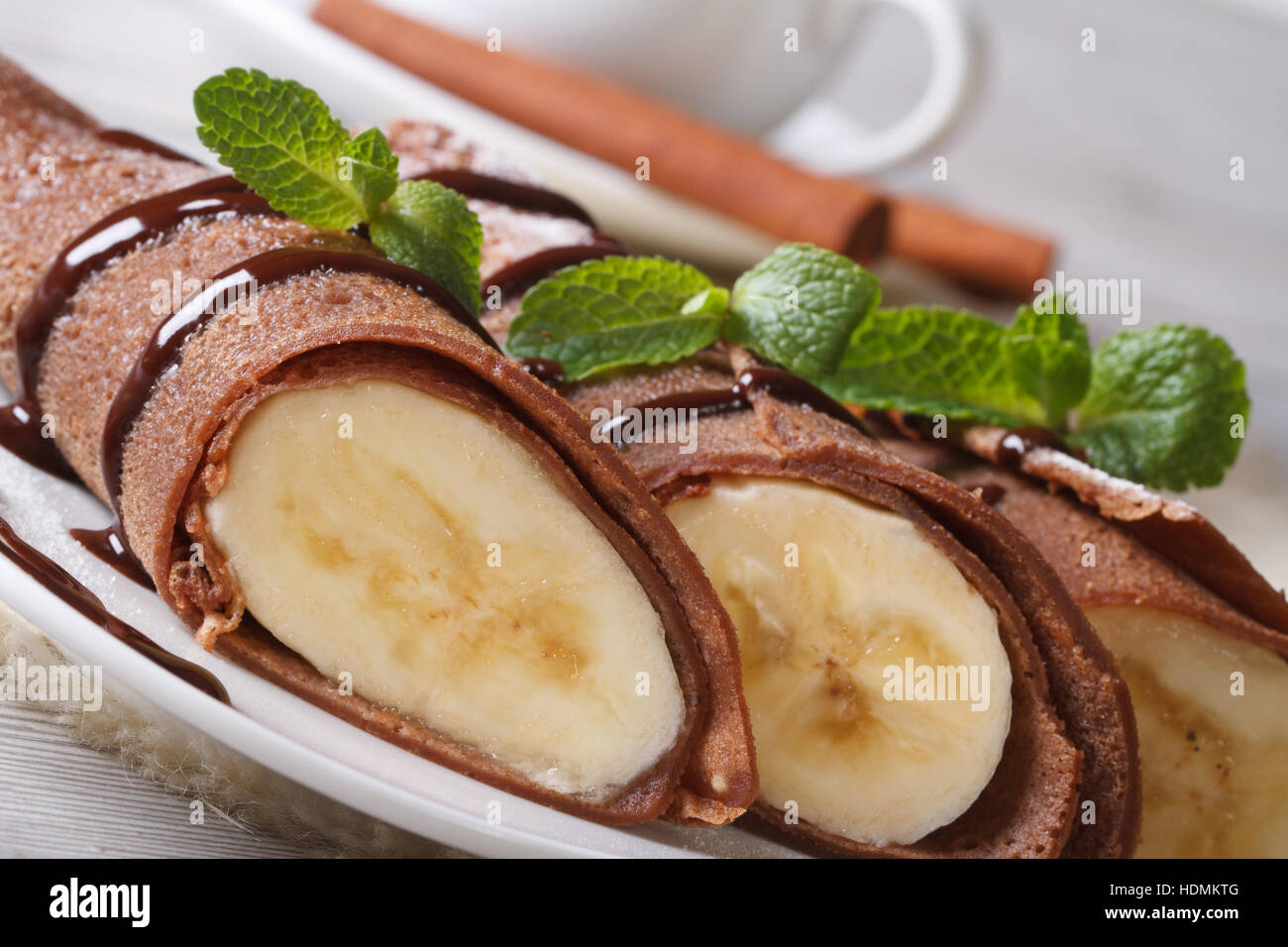 Schokolade Crepes mit Bananen Füllung Nahaufnahme auf einem weißen Teller. horizontale Stockfoto