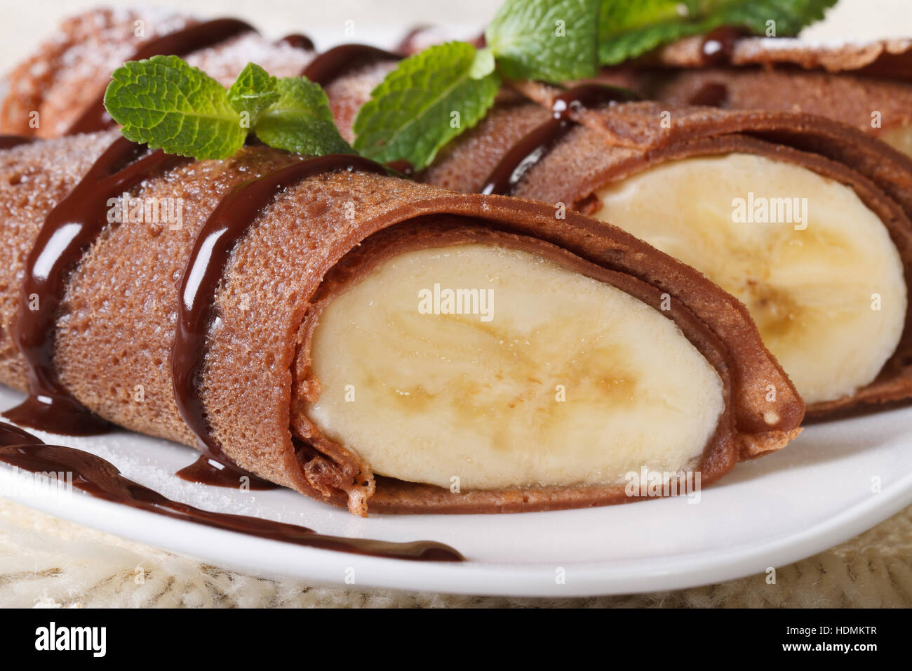 Schokolade Crepes mit Bananen Füllung Makro auf einem weißen Teller. horizontale Stockfoto