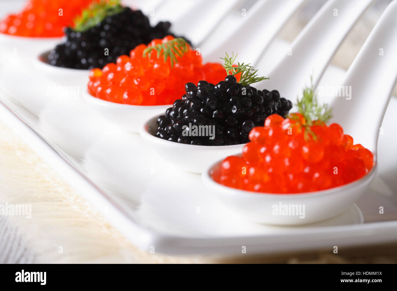 roten und schwarzen Kaviar close-up in weißen Löffel. horizontale Stockfoto