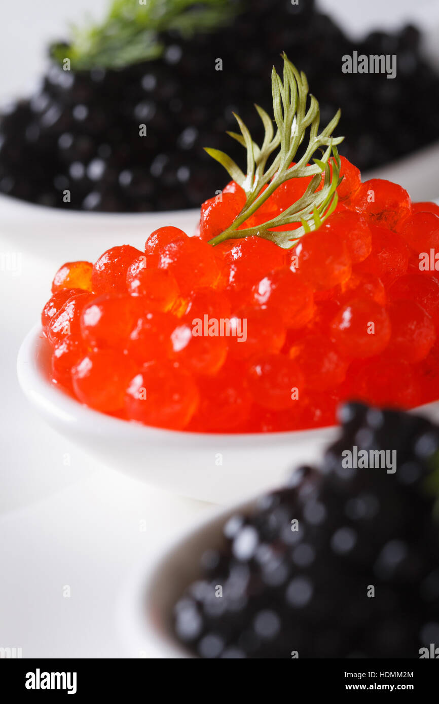 roten und schwarzen Kaviar Makro in weißen Löffel. vertikale Stockfoto