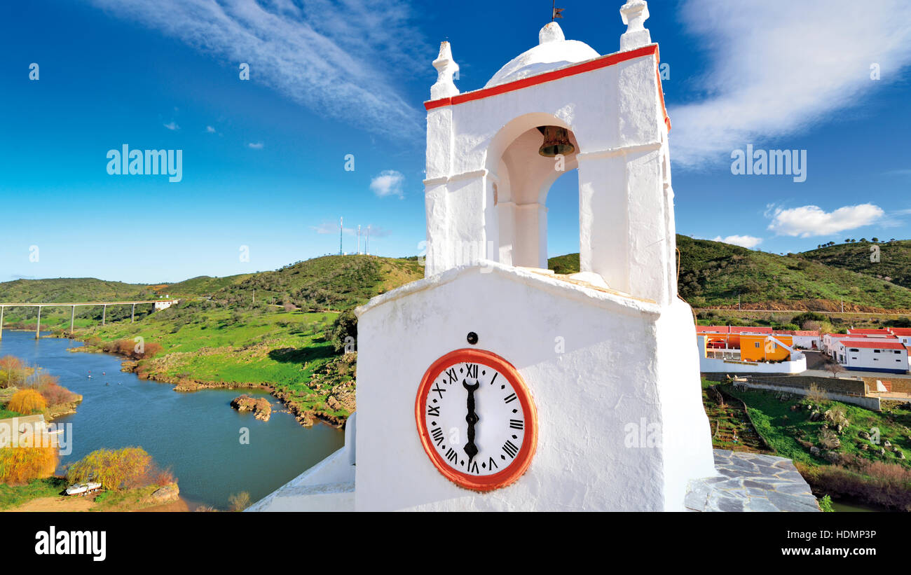 Mittelalterliche weiß gewaschen Uhrturm mit Blick auf Fluss Guadiana in der historischen Stadt Mértola. Stockfoto