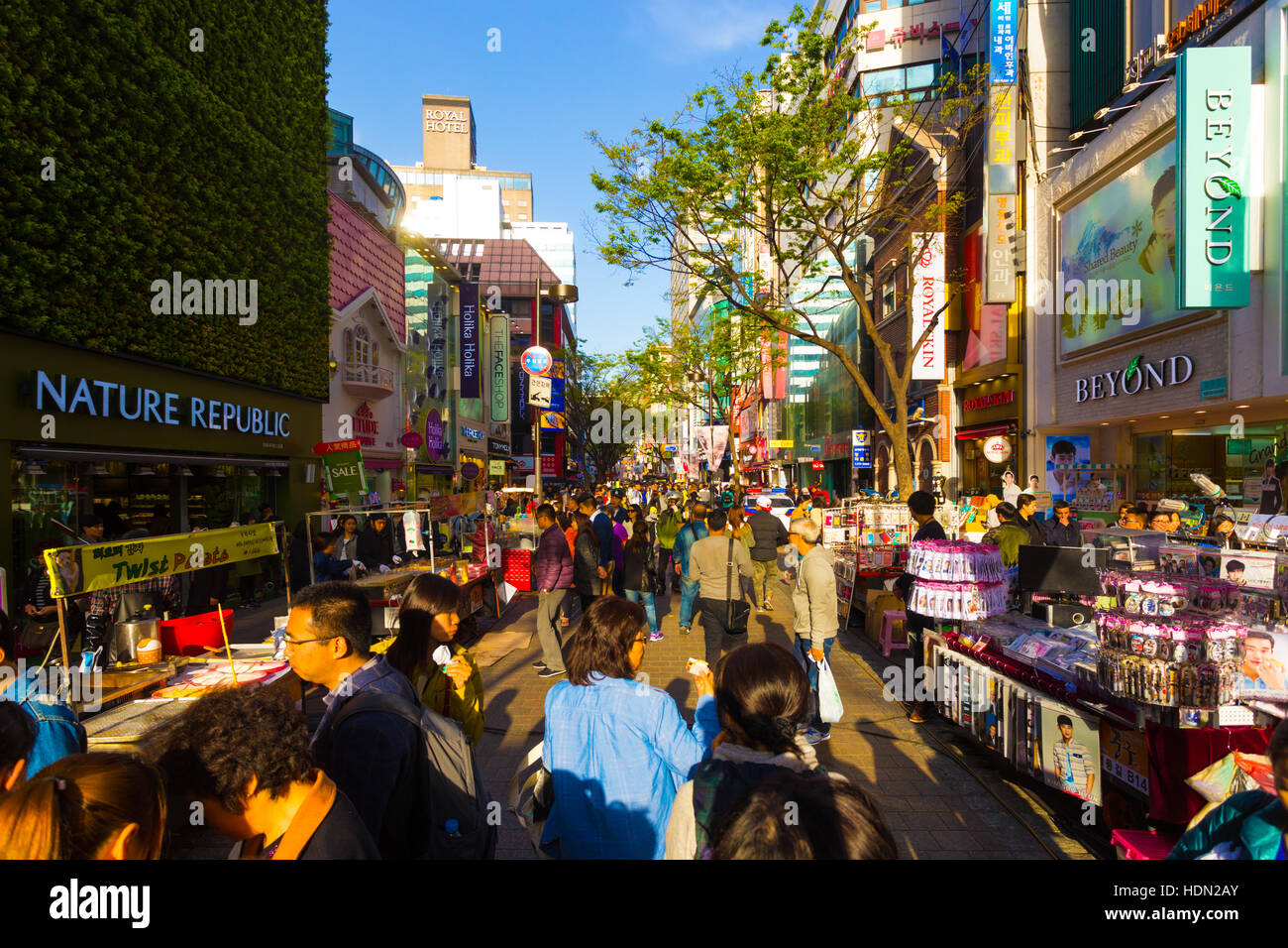 Touristen zu Fuß nach unten schmal Myeongdong Einkaufsstraße mit Kommerz Geschäfte, Schilder und überfüllt mit Menschen o Stockfoto