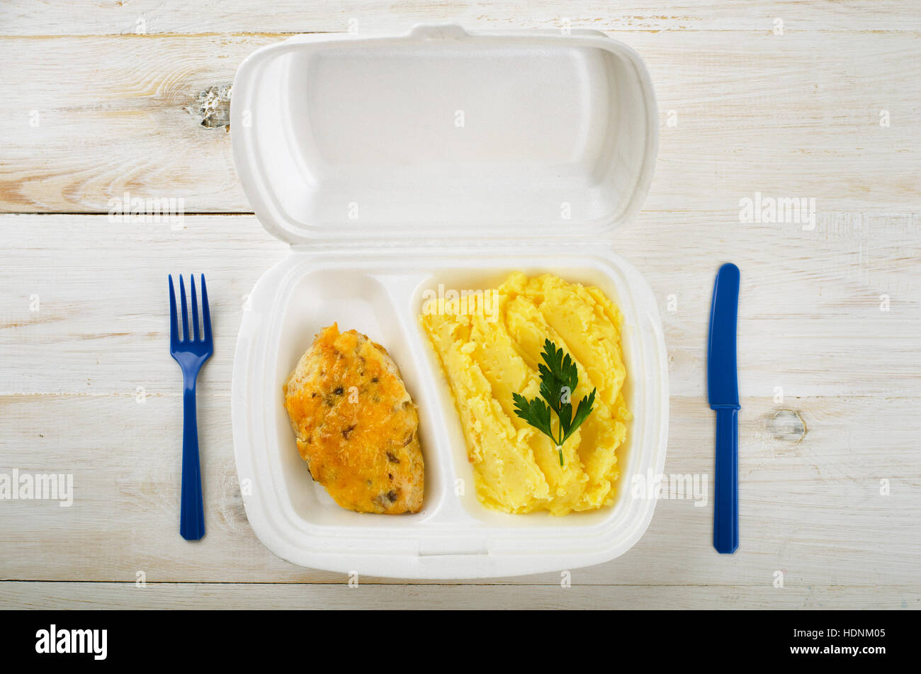 Business-Lunch: Chiken und Kartoffel Püree in Styropor-Paket auf einem Holztisch Stockfoto