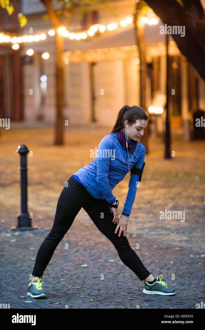Junge Läufer in der Stadt Beine dehnen und Aufwärmen Stockfoto