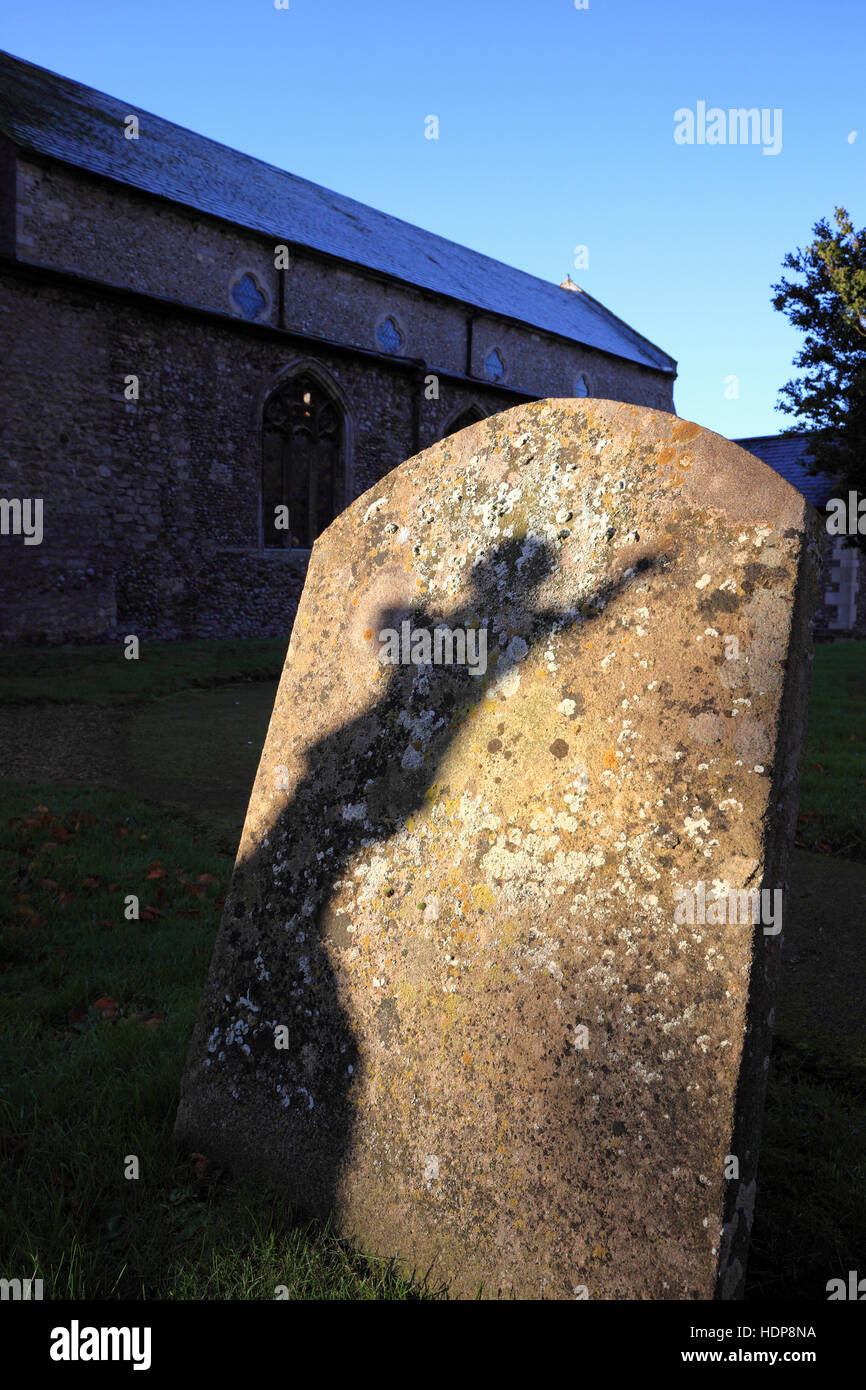 Ein Schatten auf, einen Grabstein von der Statue einer engelhaften Figur auf einem Friedhof. Stockfoto