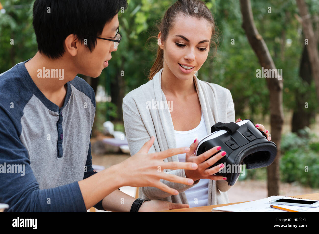 Lächelnd junges Paar reden, virtual-Reality-Brille im freien Stockfoto