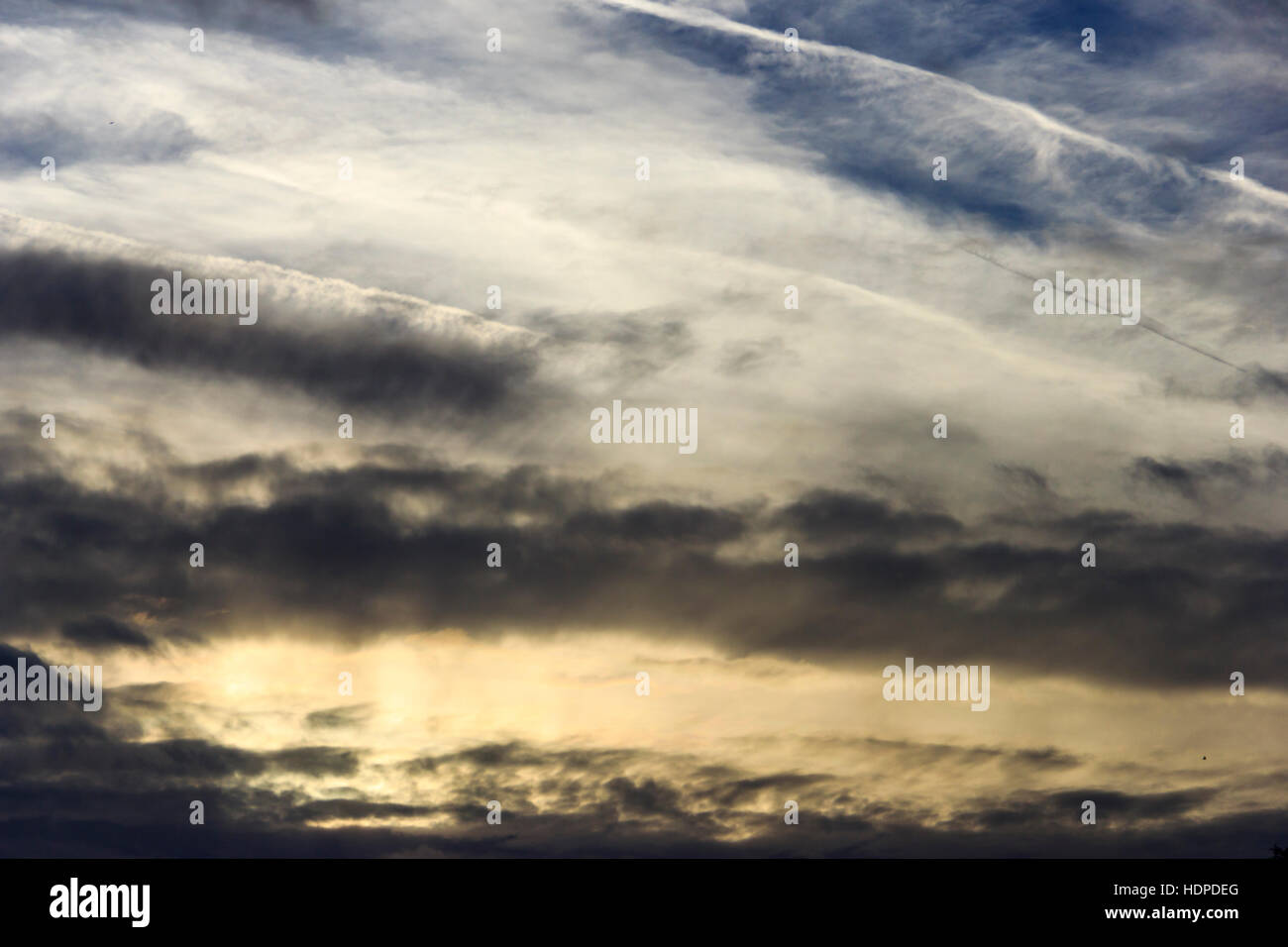 Dunkle Wolken am Himmel bei Sonnenuntergang mit dem Flugzeug Kondensstreifen Stockfoto