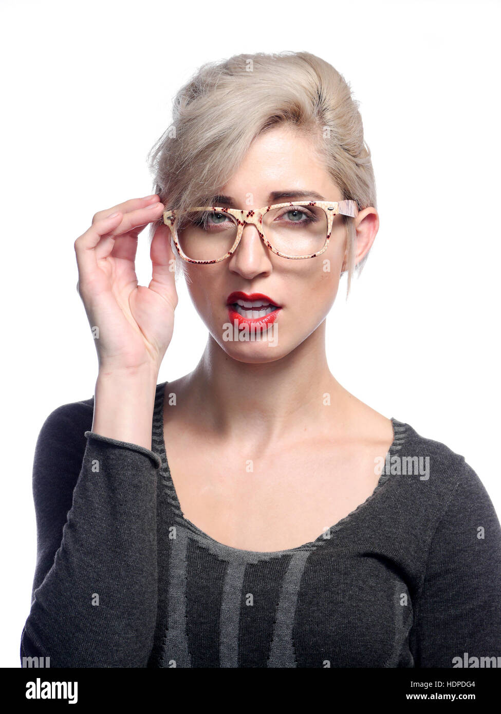Eine attraktive blonde Frau posiert vor einem weißen Hintergrund eine Brille. Stockfoto