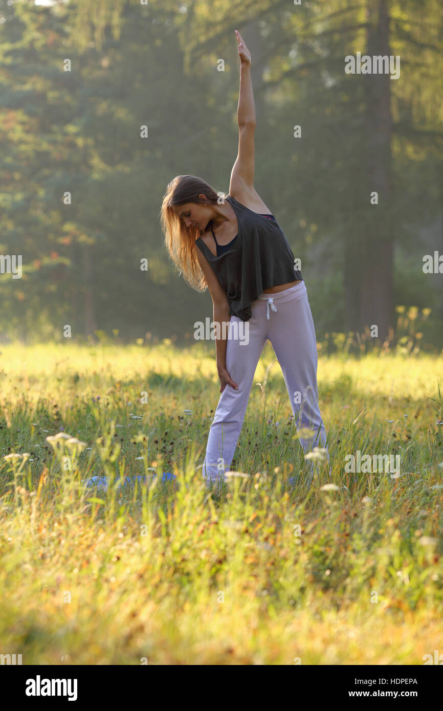 Schöne Mädchen, die Übung von Yoga in der Natur Stockfoto