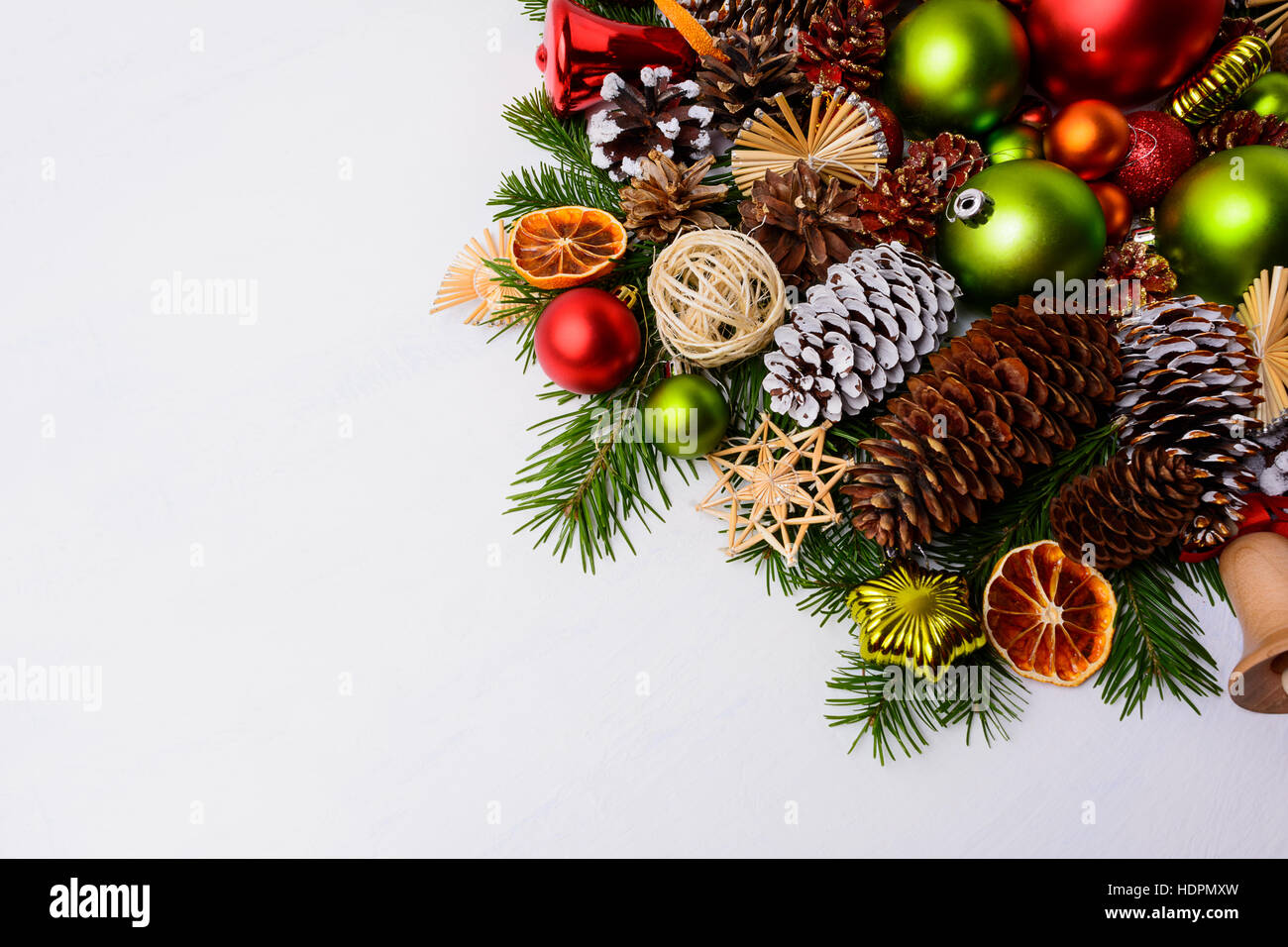 Weihnachts-Dekoration mit Tannenzapfen, roten Kugeln und grüne Ornamente. Weihnachten Hintergrund mit Christbaumkugeln und getrocknete Orangenscheiben Gruß. Kopieren Sie Raum. Stockfoto