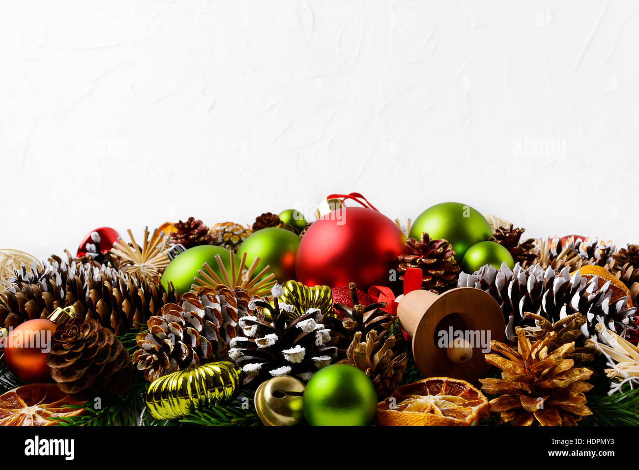 Weihnachtsgruß Hintergrund mit Hand verziert Tannenzapfen. Weihnachts-Dekoration mit grünen Ornamenten und Orangenscheiben getrocknet. Kopieren Sie Raum. Stockfoto