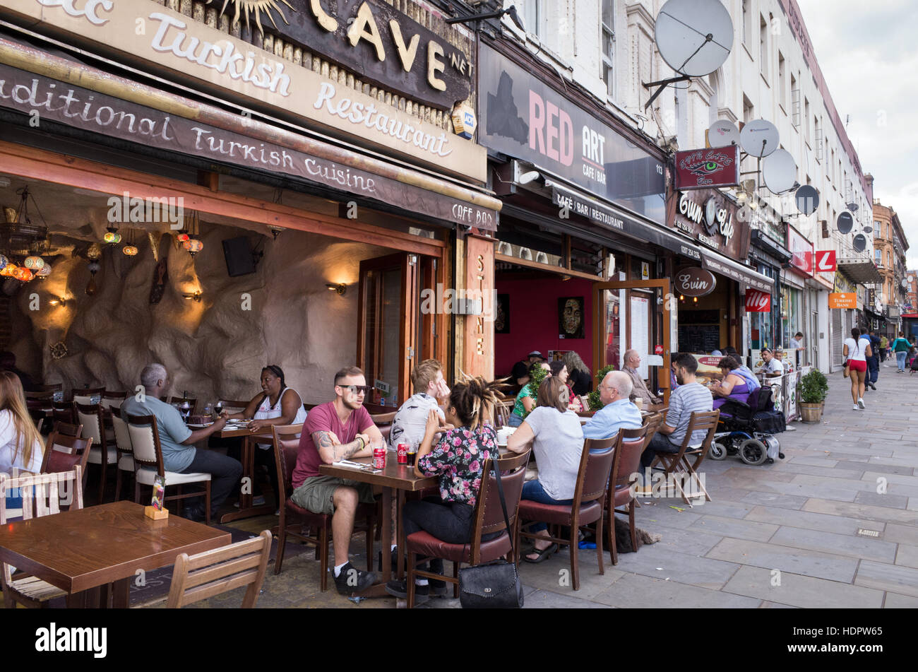 Leute sitzen an Tischen im Freien von Cafés und Restaurants auf Kingsland High Street, Dalston, Hackney, London, England, UK Stockfoto