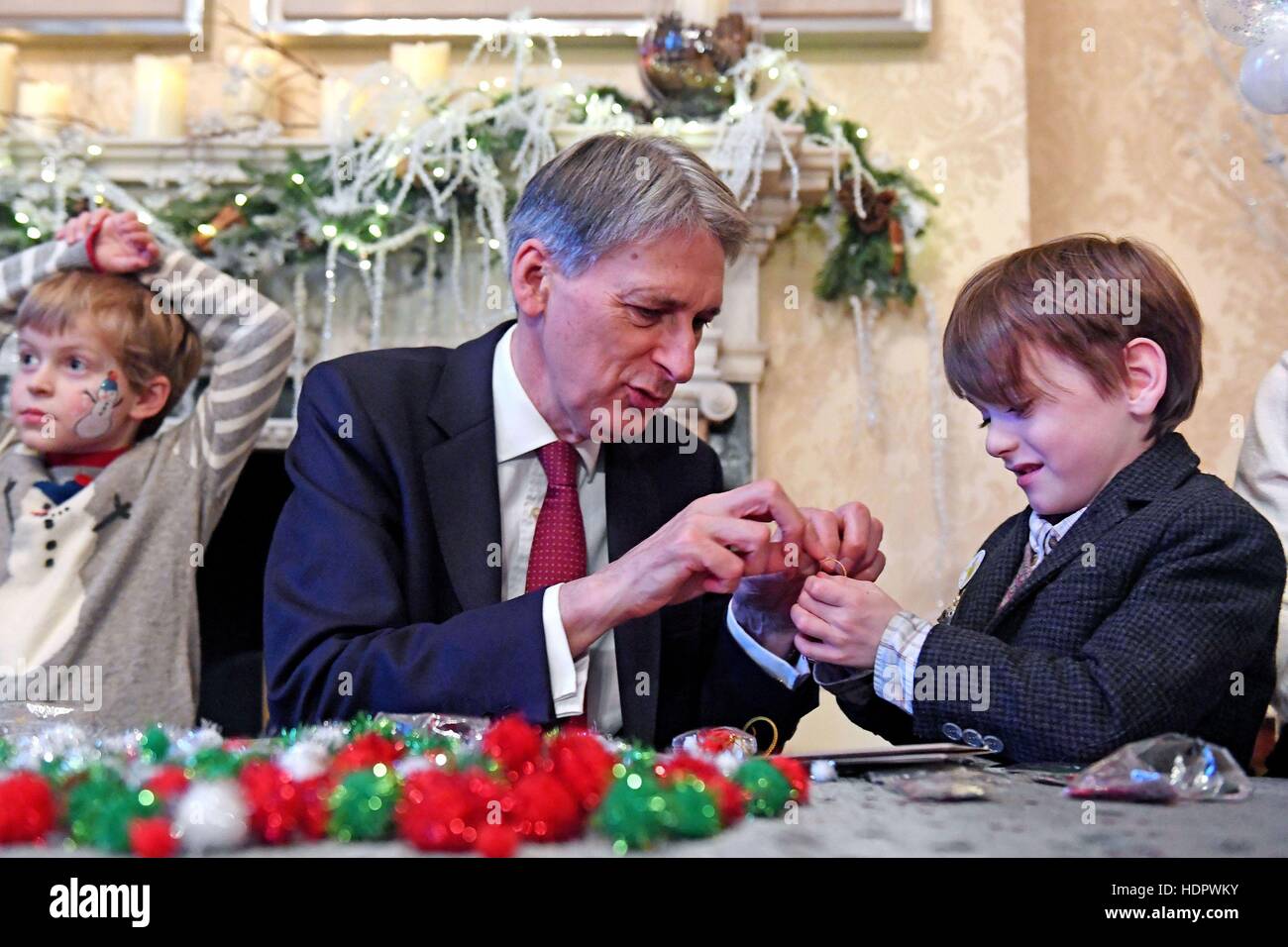 Kanzler Philip Hammond macht Weihnachtsschmuck mit Spike Coates (rechts) während der Starlight Weihnachtsfeier in 11 Downing Street in London. Stockfoto