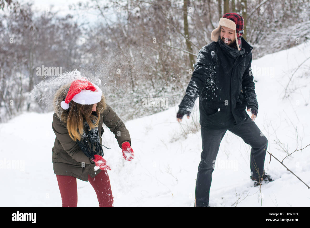 Paar im Schnee kämpfen auf dem Hügel an einem verschneiten Tag Stockfoto