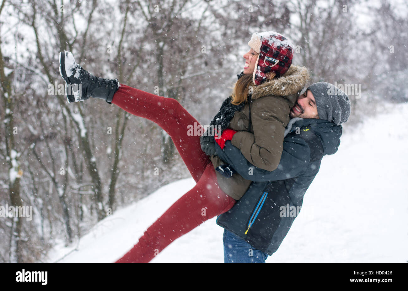 Verrückte Paare, die Spaß im Schnee bedeckt park Stockfoto