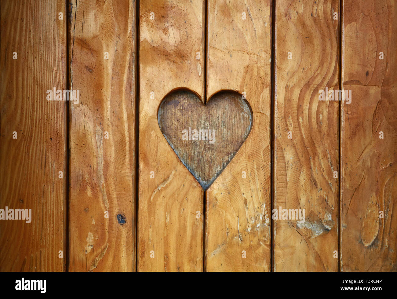 Eine Herzform, Symbol für Liebe und Romantik, Holz geschnitzt Schnitt in Vintage alte Grunge natürliche braune Holzbohlen Textur-Hintergrund, Nahaufnahme Stockfoto