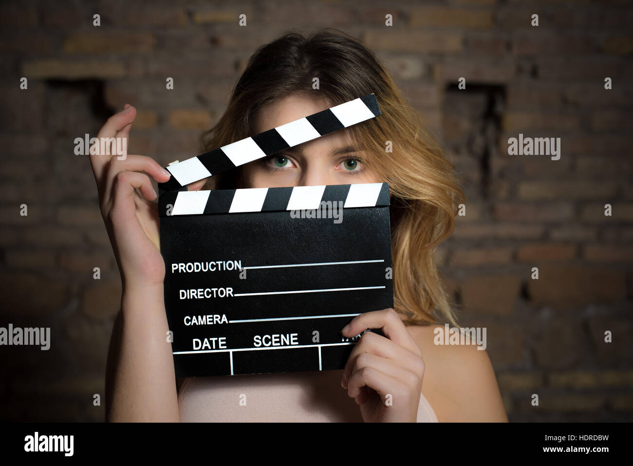 Junge grüne Augen blonde Frau Schauspielerin schließen sich mit Film Klöppel hinter Gesicht posiert Stockfoto
