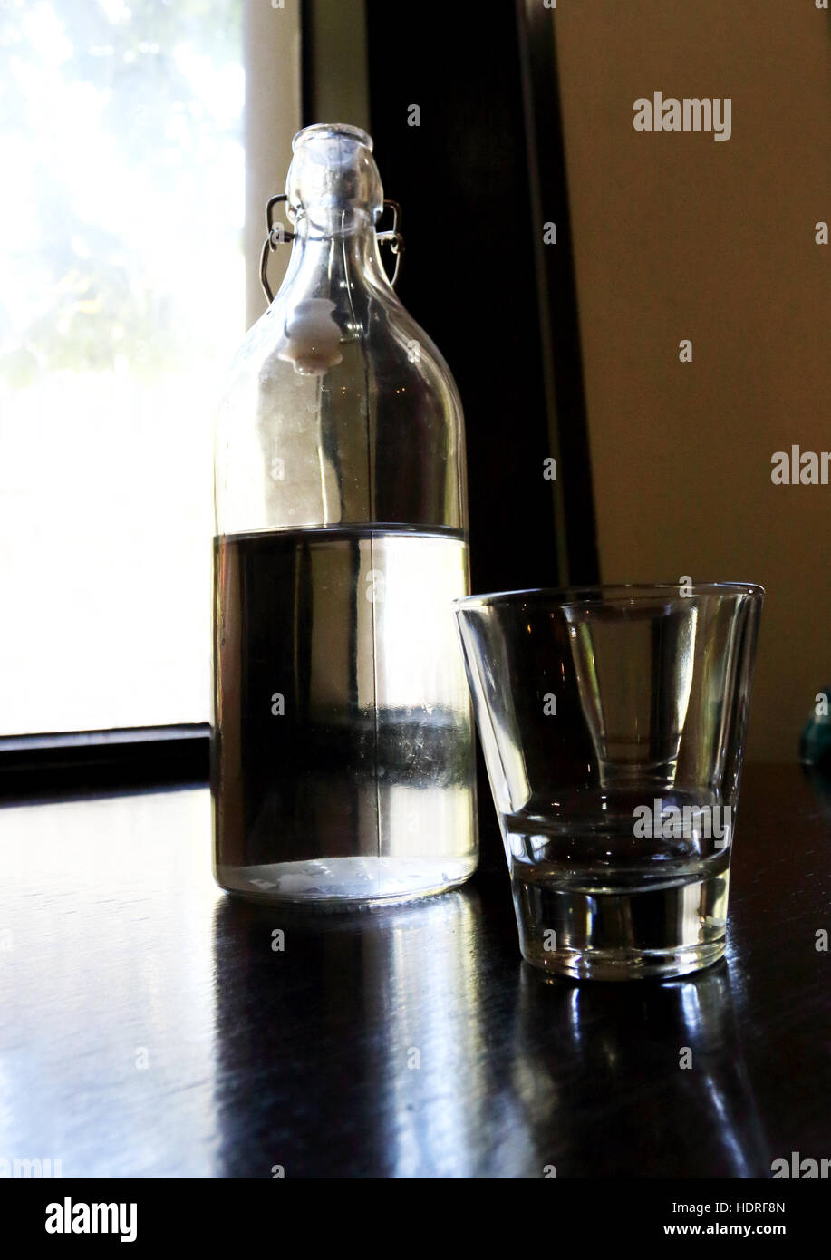 Eine Flasche Wasser mit leeren Glas auf Holztisch Stockfoto