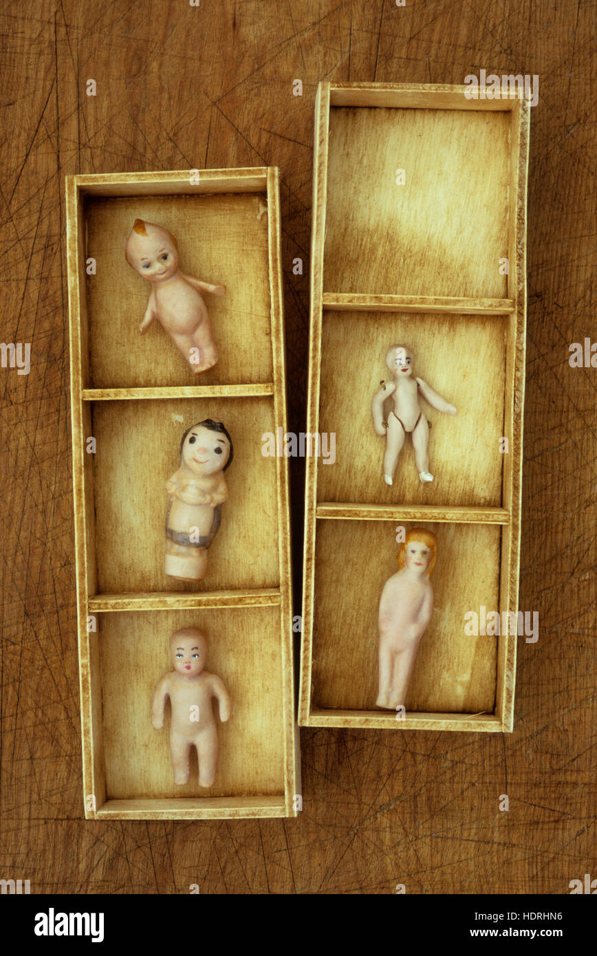 Kleinen Holztabletts mit Fächern, die mit winzigen Weinlese Bisque-Puppen Babys Kinder und Erwachsene Stockfoto