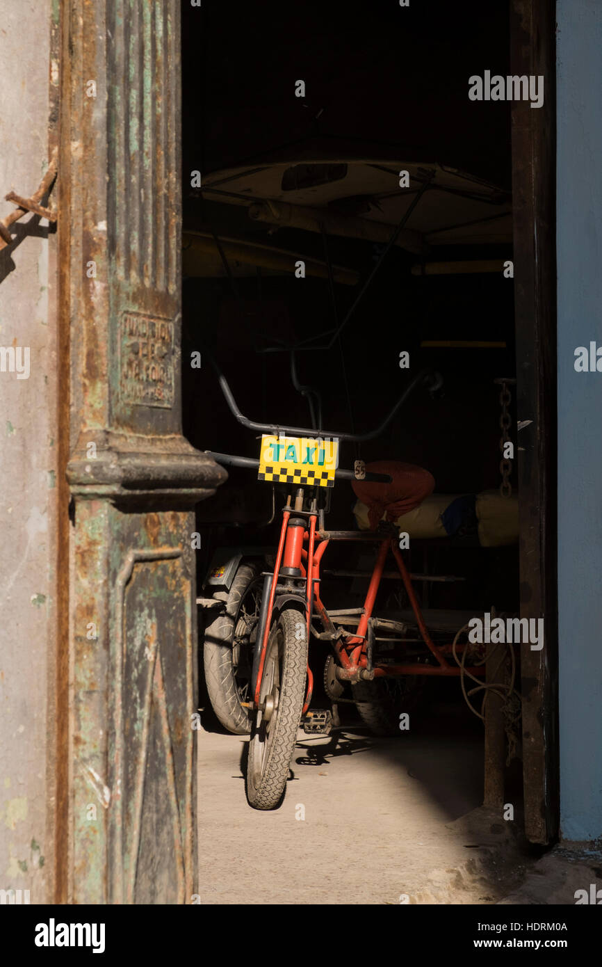 Sonnenlicht beleuchtet ein Fahrrad-Taxi in einen Parkplatz, La Havanna, Kuba. Stockfoto