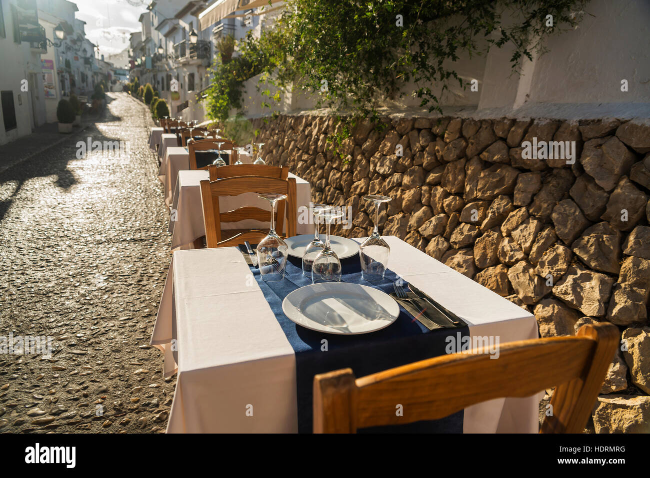 Tische für Restaurants entlang einer Straße in der schönen Stadt Altea an der Costa Blanca; Altea, Alicante, Spanien Stockfoto