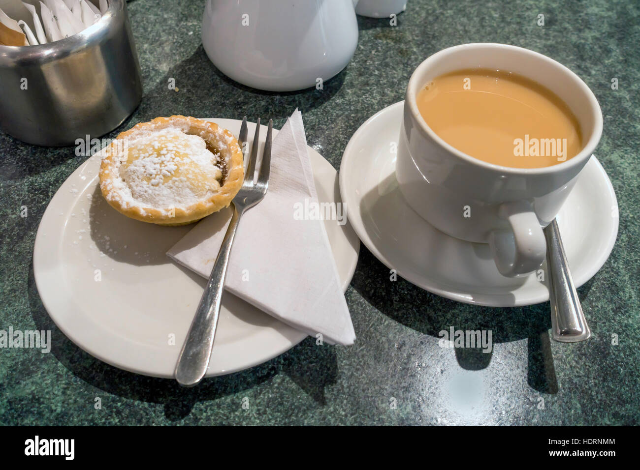 Winter-Snack in einer Yorkshire Café Tasse Tee und einem frisch gebackenen Mince Pie bestreut mit Zucker Stockfoto