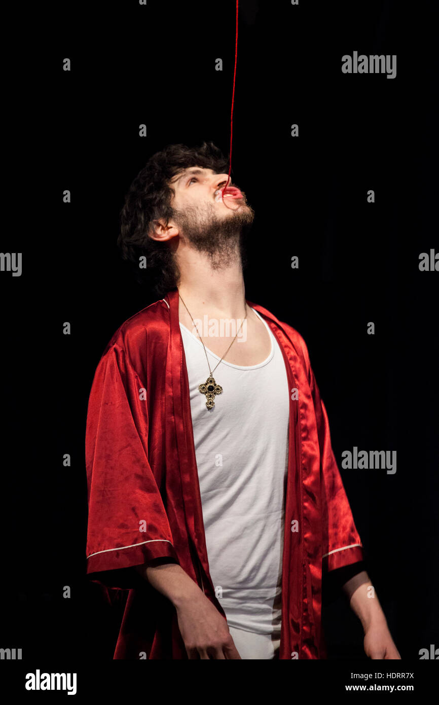 ROSTOCK / Deutschland - 12. Februar 2012: ein Schauspieler steht auf der Bühne in der Akademie für Theater und schluckt einen roten Faden Stockfoto