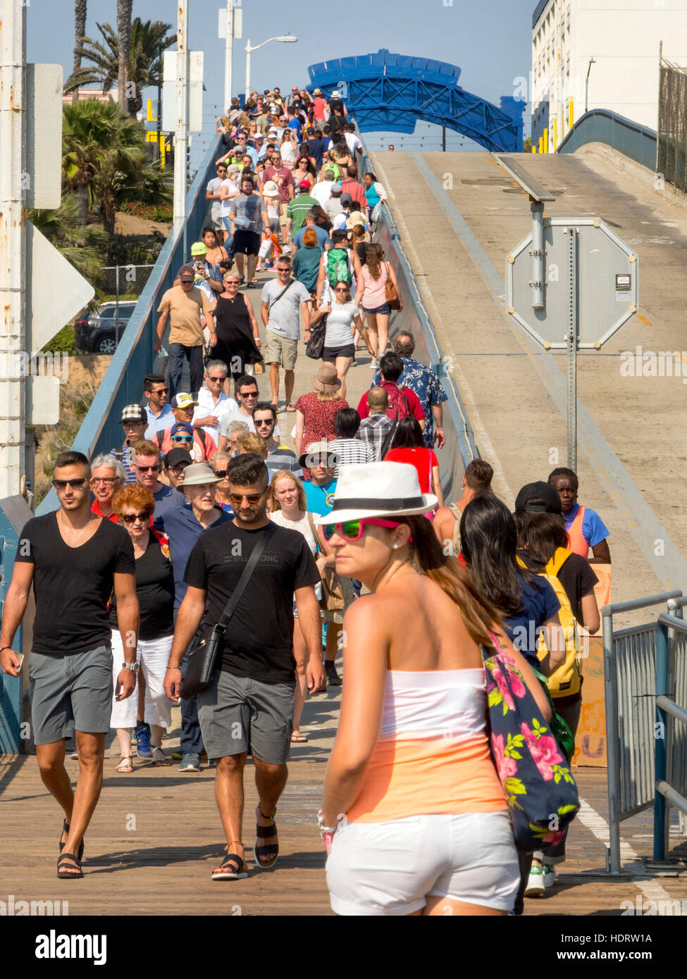 Eine multirassische Urlaub Menschenmenge strömt eine Brücke zum Vergnügen Pier in Santa Monica, Kalifornien. Stockfoto