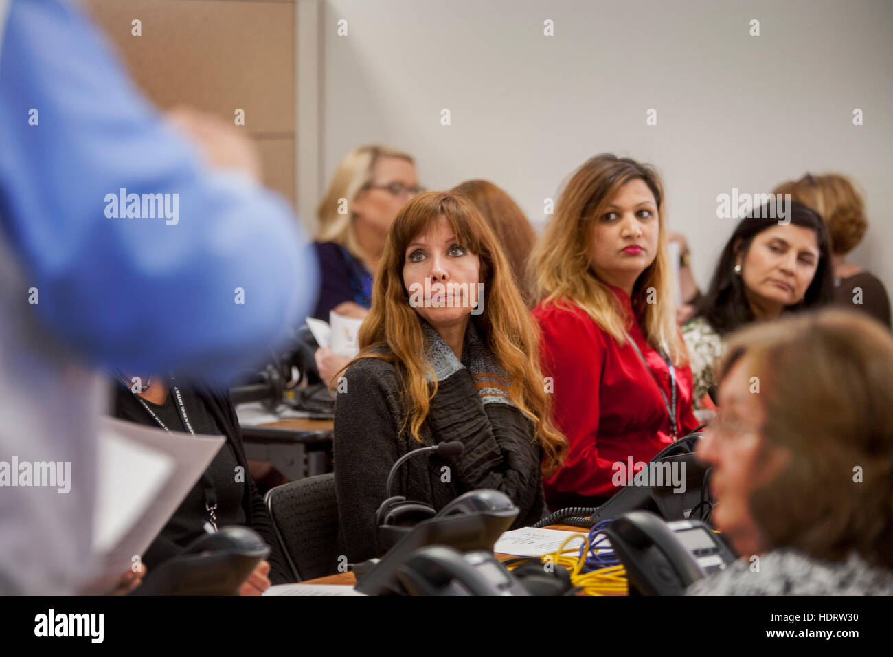 Multirassische Freiwillige Lehrer nehmen an einer Emergency Operations Center Praxis Alarm Telefon Bank in San Juan Capistrano, Kalifornien, mit potenziellen terroristischen Bedrohungen umzugehen. Hinweis-Administrator im Vordergrund. Stockfoto