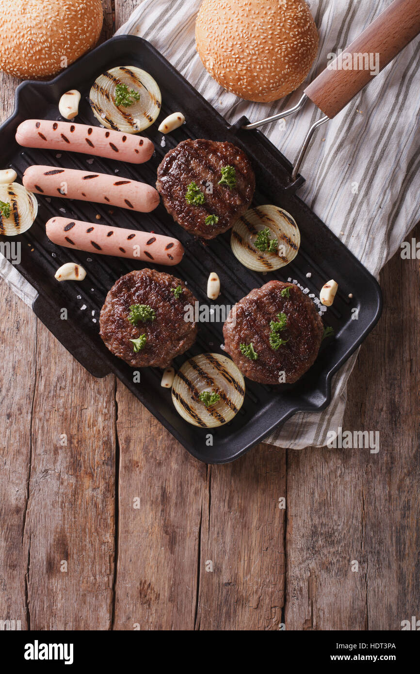 Gegrillte Hamburger und Hot Dogs auf die Grillpfanne. vertikale Ansicht von oben Stockfoto