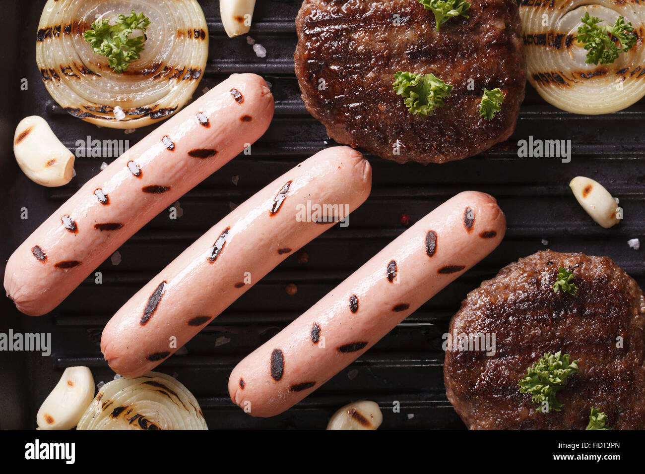 Burger und Würstchen mit Grillgemüse Closeup. horizontale Ansicht von oben Stockfoto