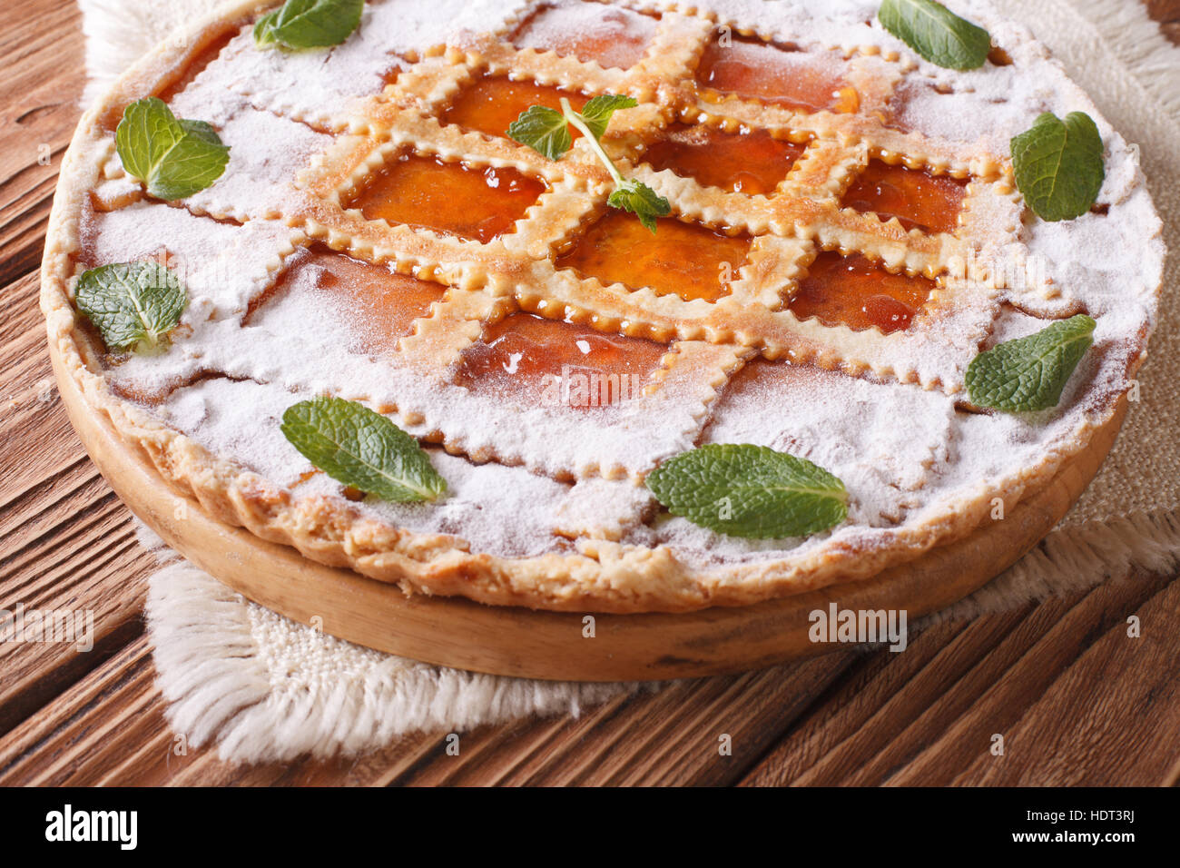 Italienische Torte mit Marillenmarmelade und Minze hautnah auf dem Tisch. horizontale Stockfoto