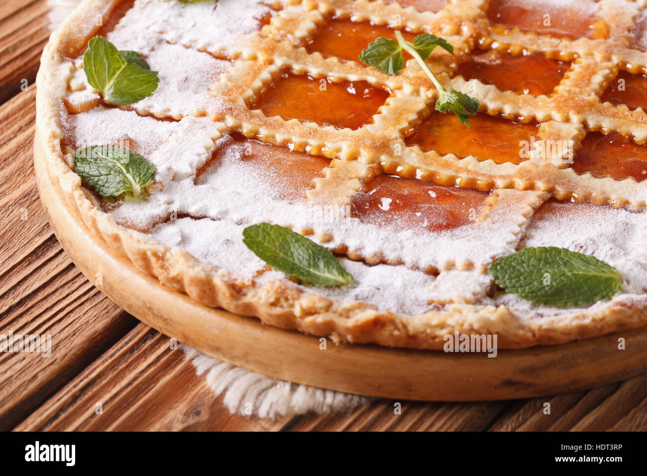Leckere italienische Crostata mit Marillenmarmelade und Minze auf einem Holztisch. horizontale Stockfoto