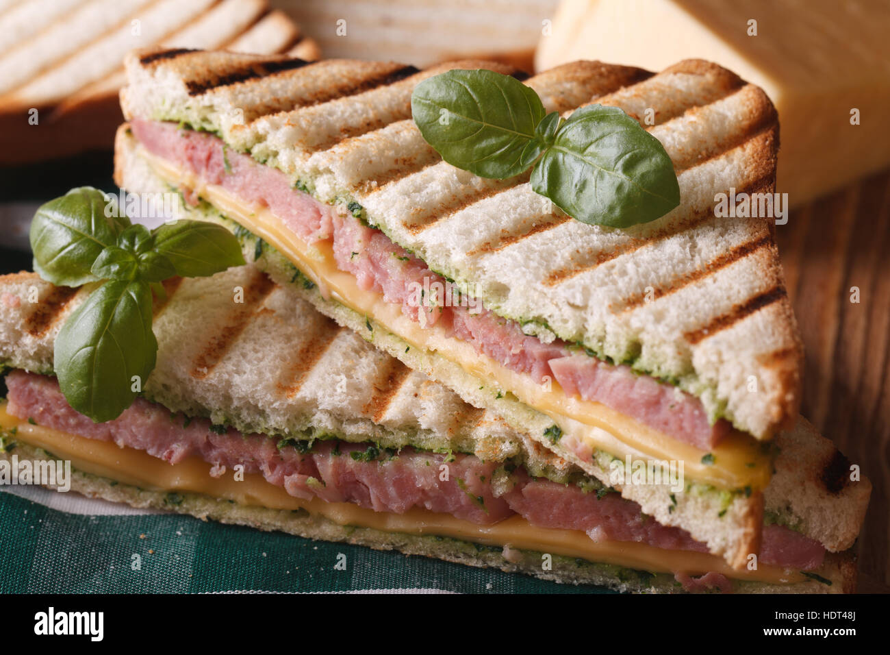 Gegrilltes Sandwich mit Schinken, Käse und Basilikum Nahaufnahme auf dem Tisch. horizontale Stockfoto