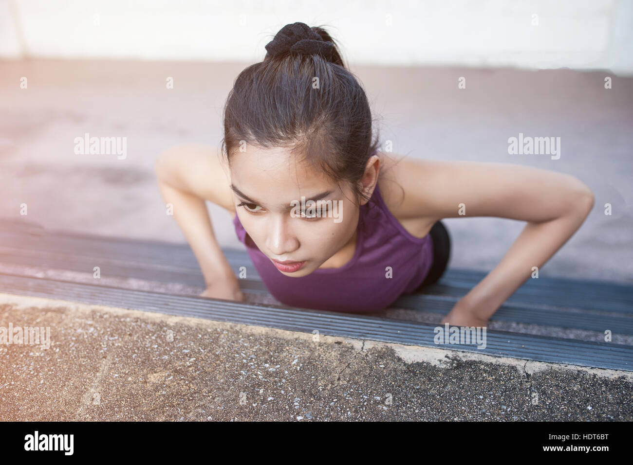 Urbane junge athletische Sportlerin doing Push-ups. Muskulös und kräftig trainieren. Stockfoto