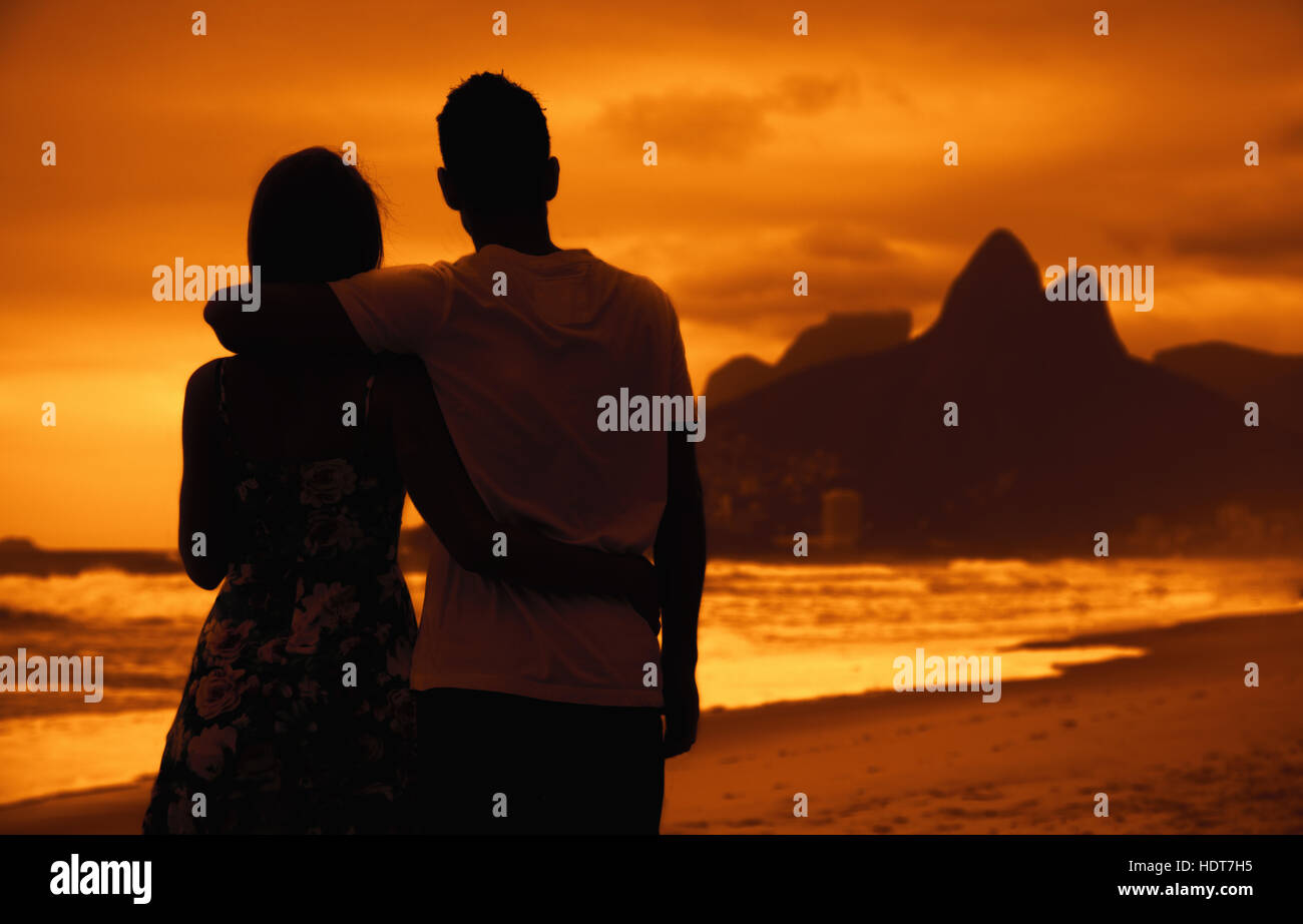 Liebespaar in Armen im Freien am Strand bei Sonnenuntergang in Rio De Janeiro Stockfoto