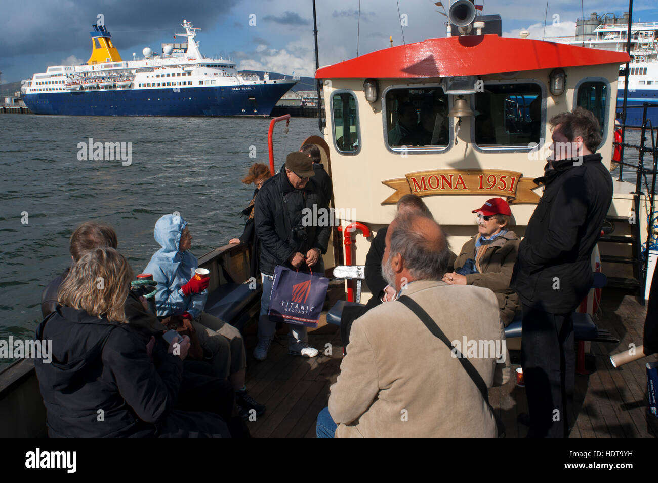 Die rote geschälten touristischen Boot Mona im Fluss Lagan in Belfast Nordirland Vereinigtes Königreich UK festgemacht. Saga Pearl II große Kreuzfahrt mit Belfast angedockt. Stockfoto