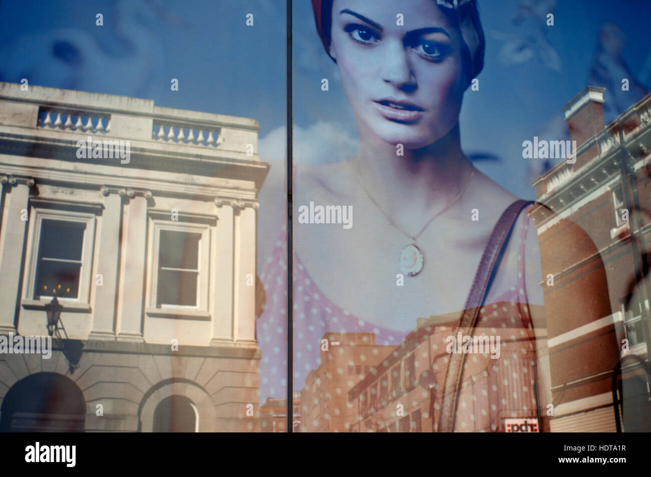 Reflexionen in einem Fenster eines der Geschäfte im Zentrum von Belfast, Nordirland, Vereinigtes Königreich. Belfasts Stadtzentrum bietet eine gesunde Mischung aus hoher stree Stockfoto