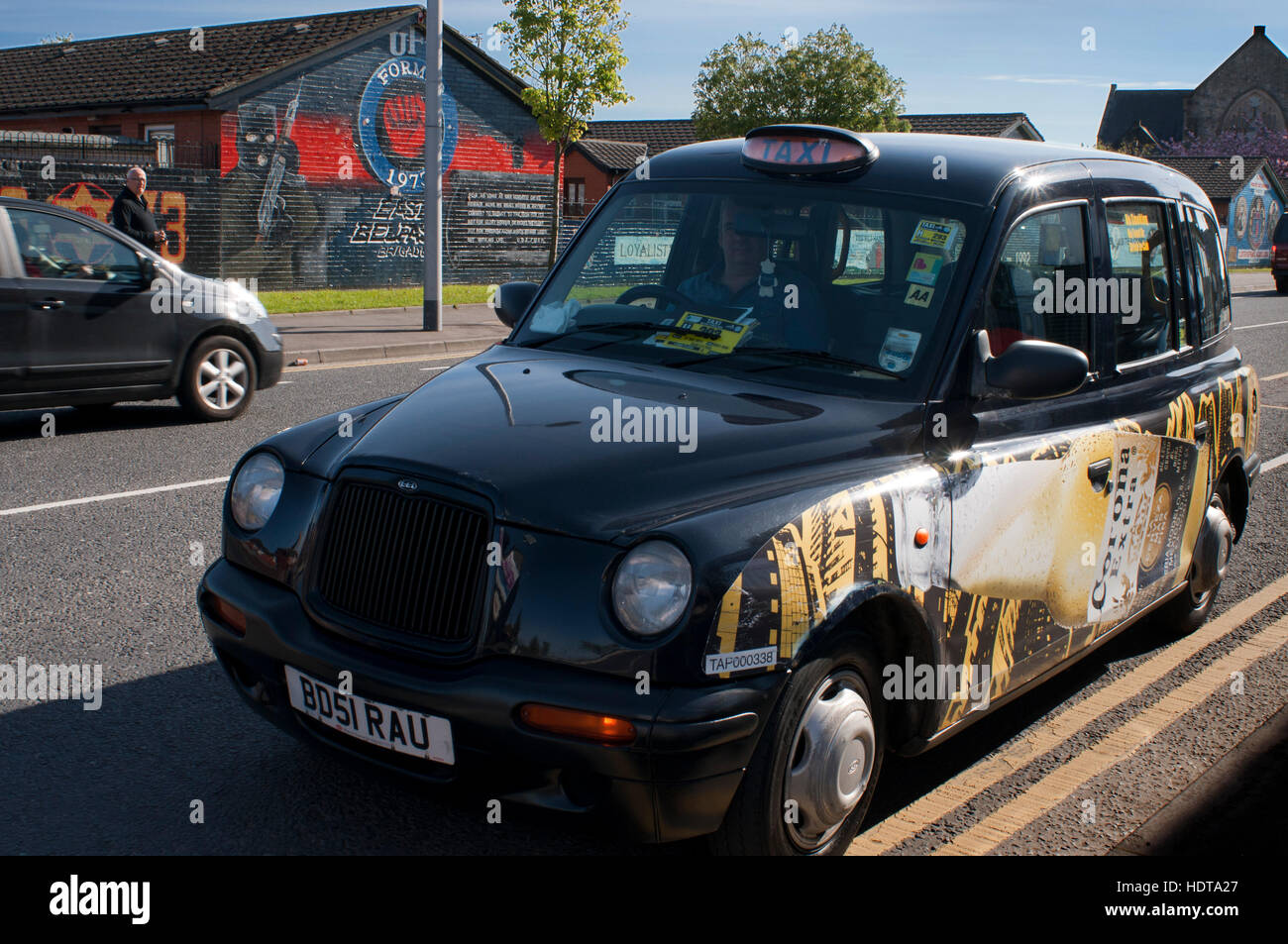 Belfast Black Taxi Tour vor einem der Loyalist Wandbilder am unteren Rand der Newtownards Straße in East Belfast, Nordirland, Vereinigtes Königreich. U.F.F. Mu Stockfoto