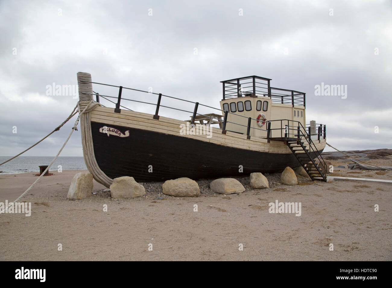 Die Beluga, ein Boot am Ufer der Hudson Bay in Churchill in Manitoba, Kanada. Das Boot steht auf Sand von der Küste. Stockfoto