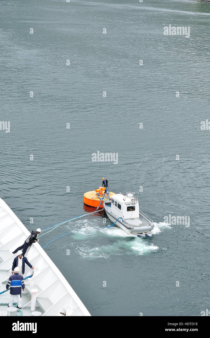 Ein großes Schiff mit Hilfe von Schlepper und große Boje festmachen. Arbeiten auf hoher See. Team-Arbeit Stockfoto