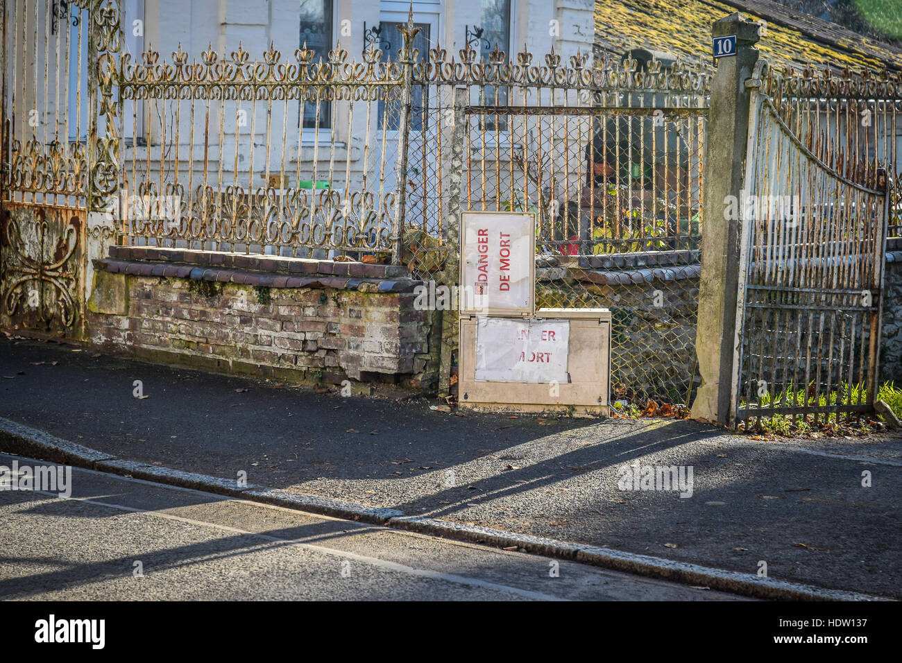 Gefahr von Tod--Danger de Mort--Warnung melden Sie auf einem elektrischen Feld außerhalb eine reich verzierte Zaun im ländlichen Frankreich. Stockfoto