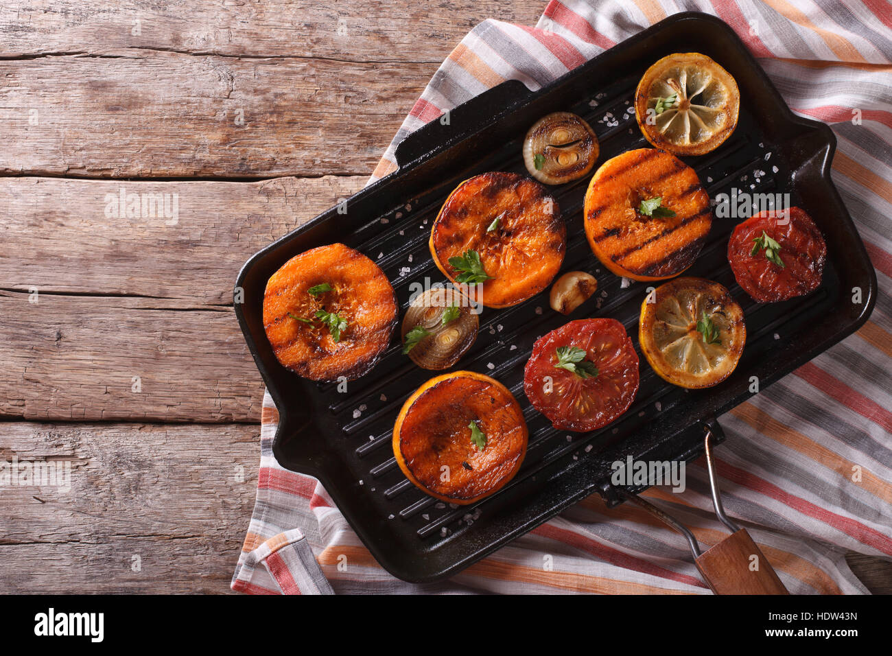 Kürbis, Tomaten, Zwiebeln und Zitronen auf dem Grill schwenken. horizontale Ansicht von oben Stockfoto