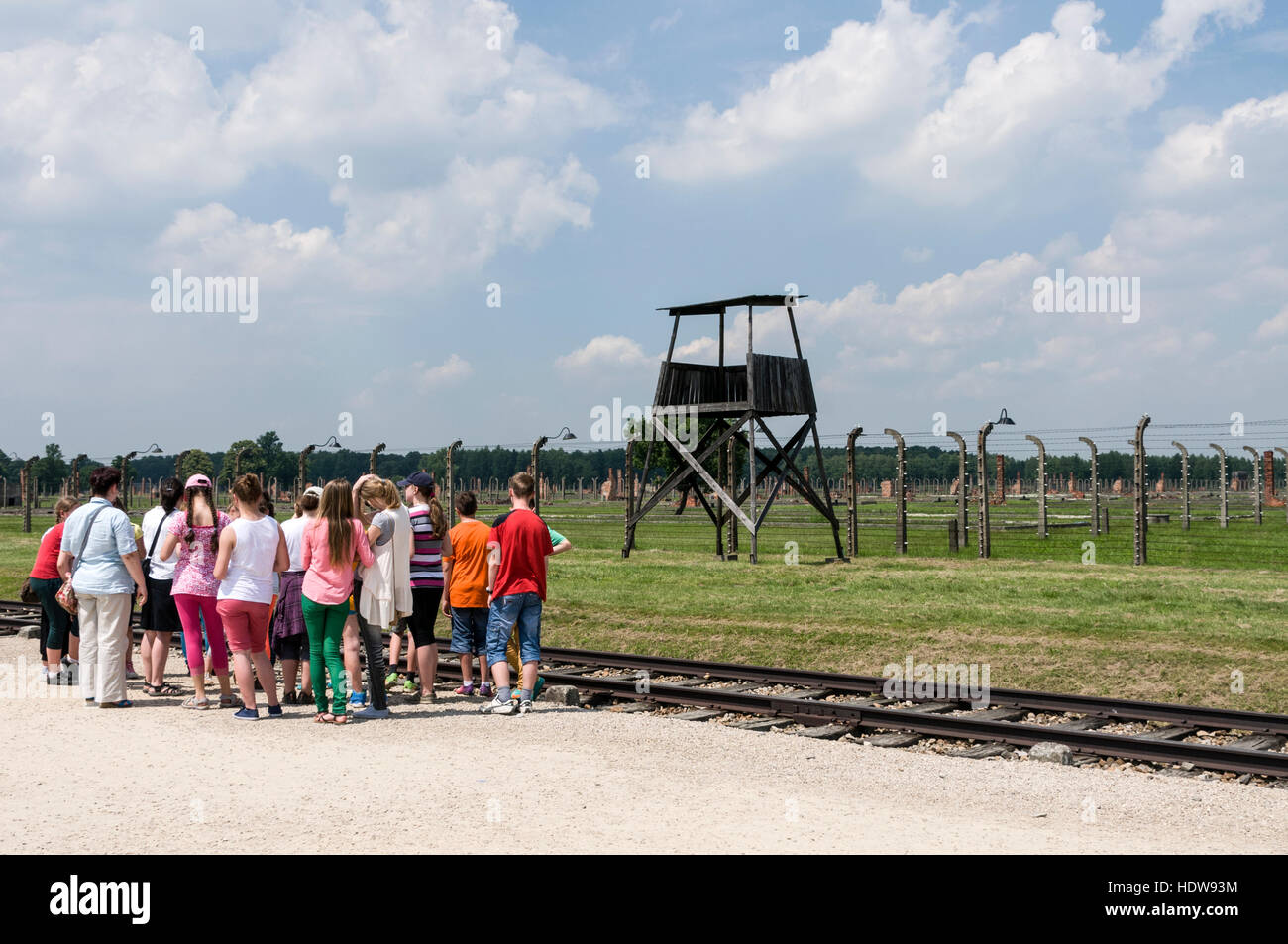Eine Gruppe von Schülerinnen und Schüler am Ende der Zeile für Tausende von Juden und anderen Opfern des Holocaust in Auschwitz 11-Birkenau mit dem Zug anreisen Stockfoto